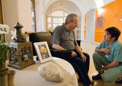 Ein Senior im Gespräch mit einer Pflegekraft