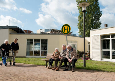 Eine Gruppe von älteren Menschen wartet vor der Hausgemeinschaft Demenz