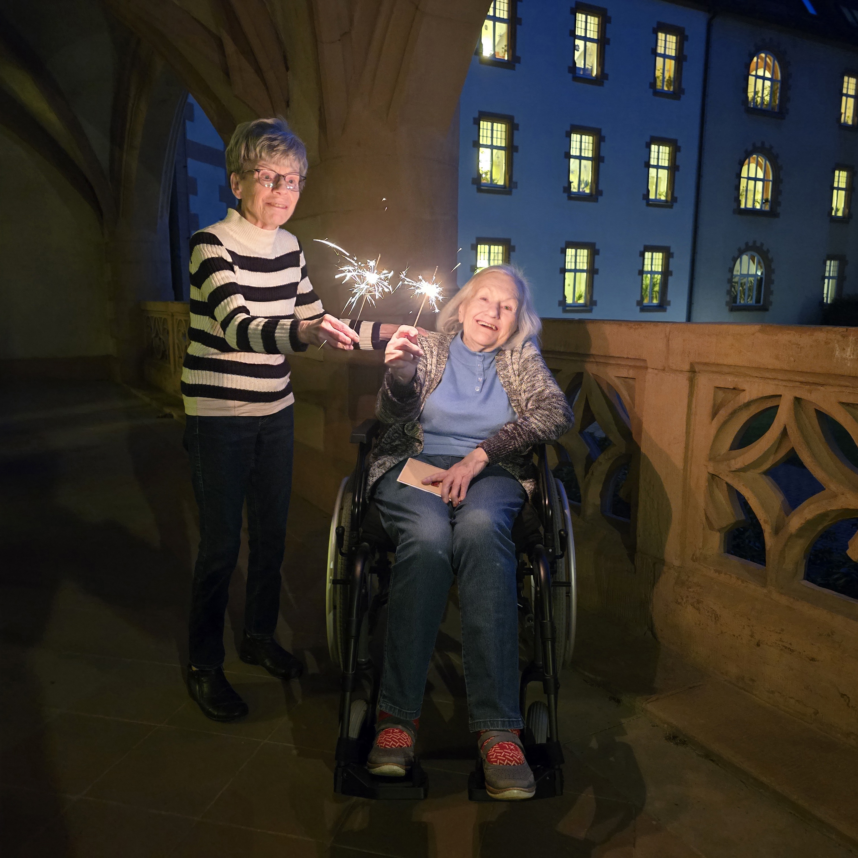 Einen guten Rutsch wünschen die Bewohnerinnen und Bewohner des Altenpflegeheims Riebeckpark! © Paul-Riebeck-Stiftung Zwei Bewohnerinnen des Altenpflegeheims Riebeckpark verabschieden das alte Jahr 2025 mit Wunderkerzen auf der Terrasse.