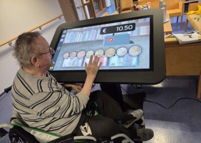 Ein Bewohner des Altenpflegeheims Akazienhof am CareTable – einem interaktiven Aktivitätstisch für Spiele und Medien.