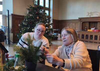 Bewohner des Altenpflegeheims Riebeckpark und Kinder der Kita im Riebeckpark basteln weihnachtliche Gestecke.