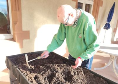 Bewohner des Altenpflegeheim Riebeckpark beim Setzen der ersten Frühlingszwiebeln in der Ergotherapie.